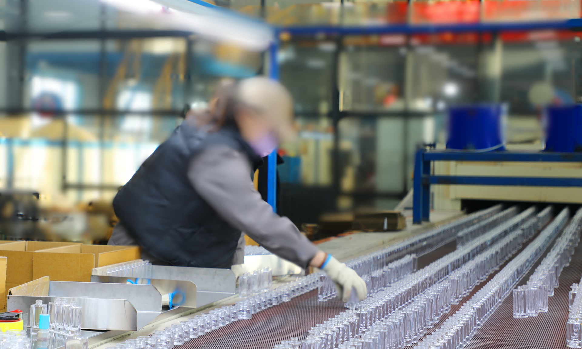 Operator inspecting perfume bottles on production line