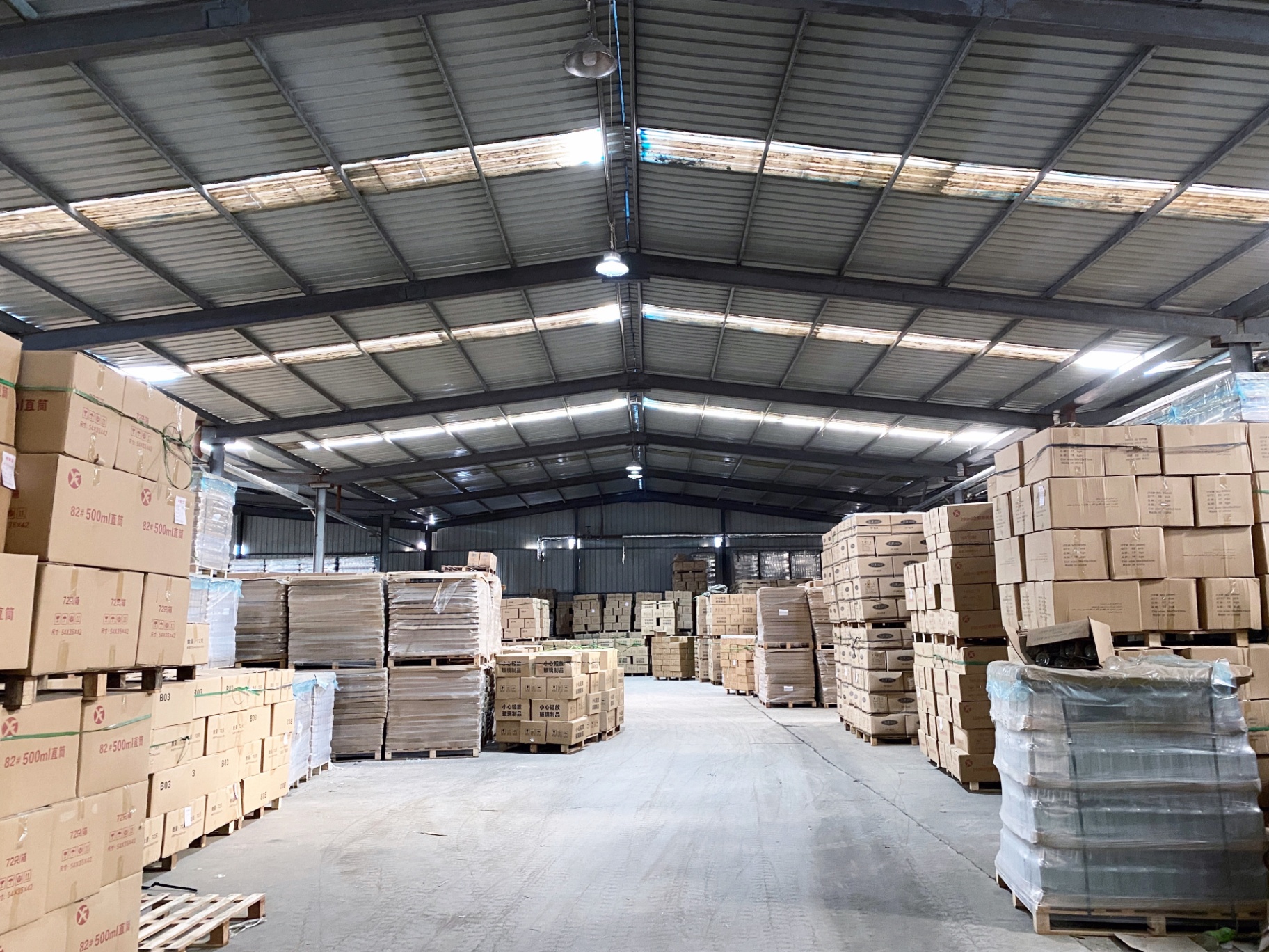 Packed cartons of glass bottles stacked on pallets in the warehouse ready for dispatch